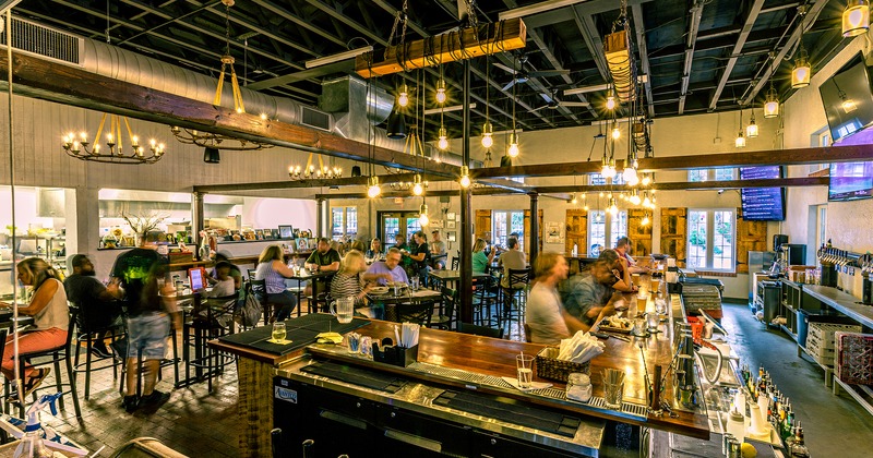 Interior, bar and seating area with guests dining
