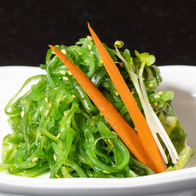 A seaweed salad, garnished with carrot strips.