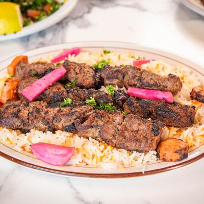 Lamb kebabs over seasoned rice.