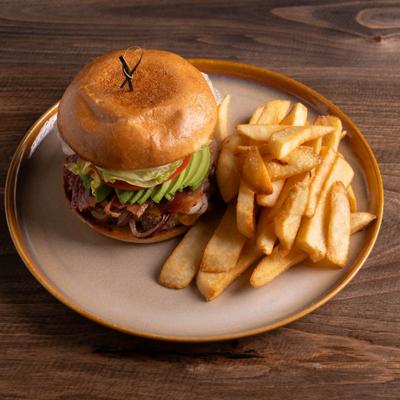Roxanne burger served with fries on a round plate.