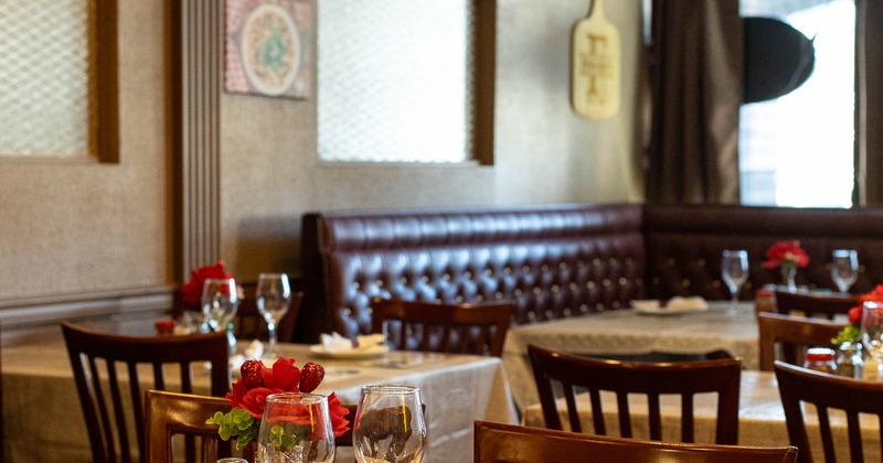Interior, dining area, golden cloth tables with wooden chairs, corner bench in the back