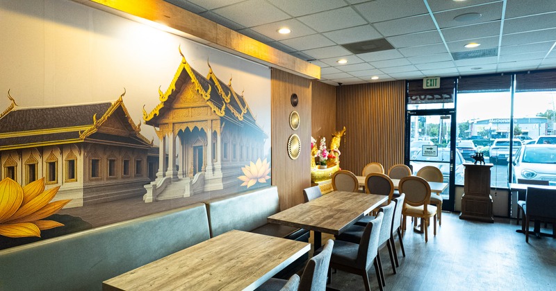 Restaurant interior with a large mural of a temple, cushioned seating, and decorative accents