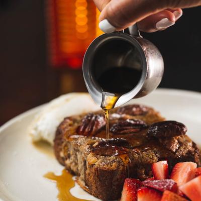 French toast, with whipped cream, strawberries and maple syrup.