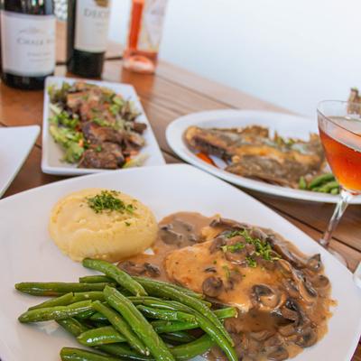 Chicken marsala, green beans and mashed potatoes  on a table with served food.