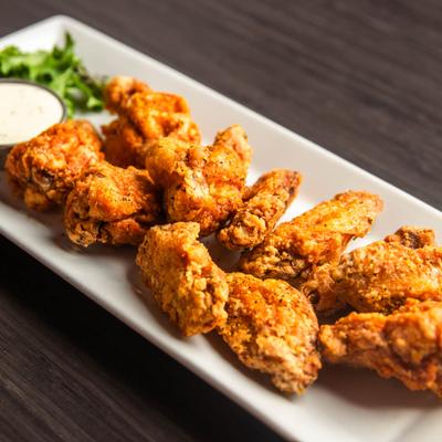 Lemon pepper breaded wings served with a dipping sauce.