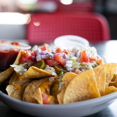 Nachos topped with chicken, onions, cheese, and tomatoes.