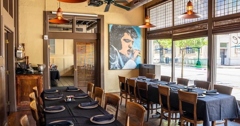 Interior, long dining tables with tableware, picture on the wall