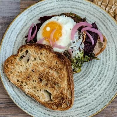 Toast with a fried egg, cashew butter, onion pickle, pumpkin chickpea spread