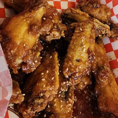 Glazed chicken wings topped with sesame seeds.