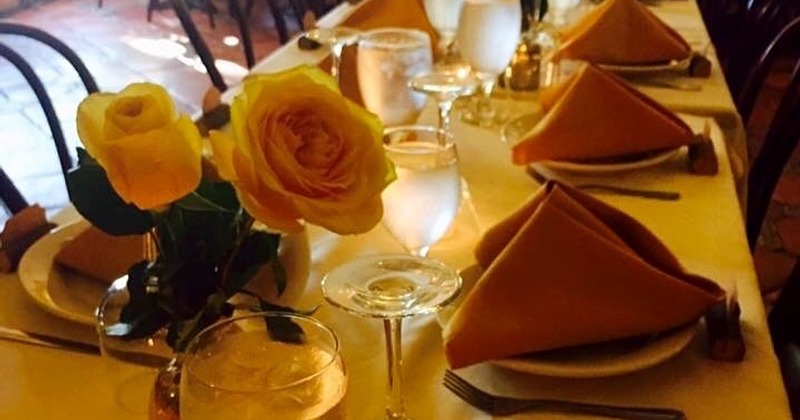 Table set with flower arrangements, napkins, plates, glasses and candles