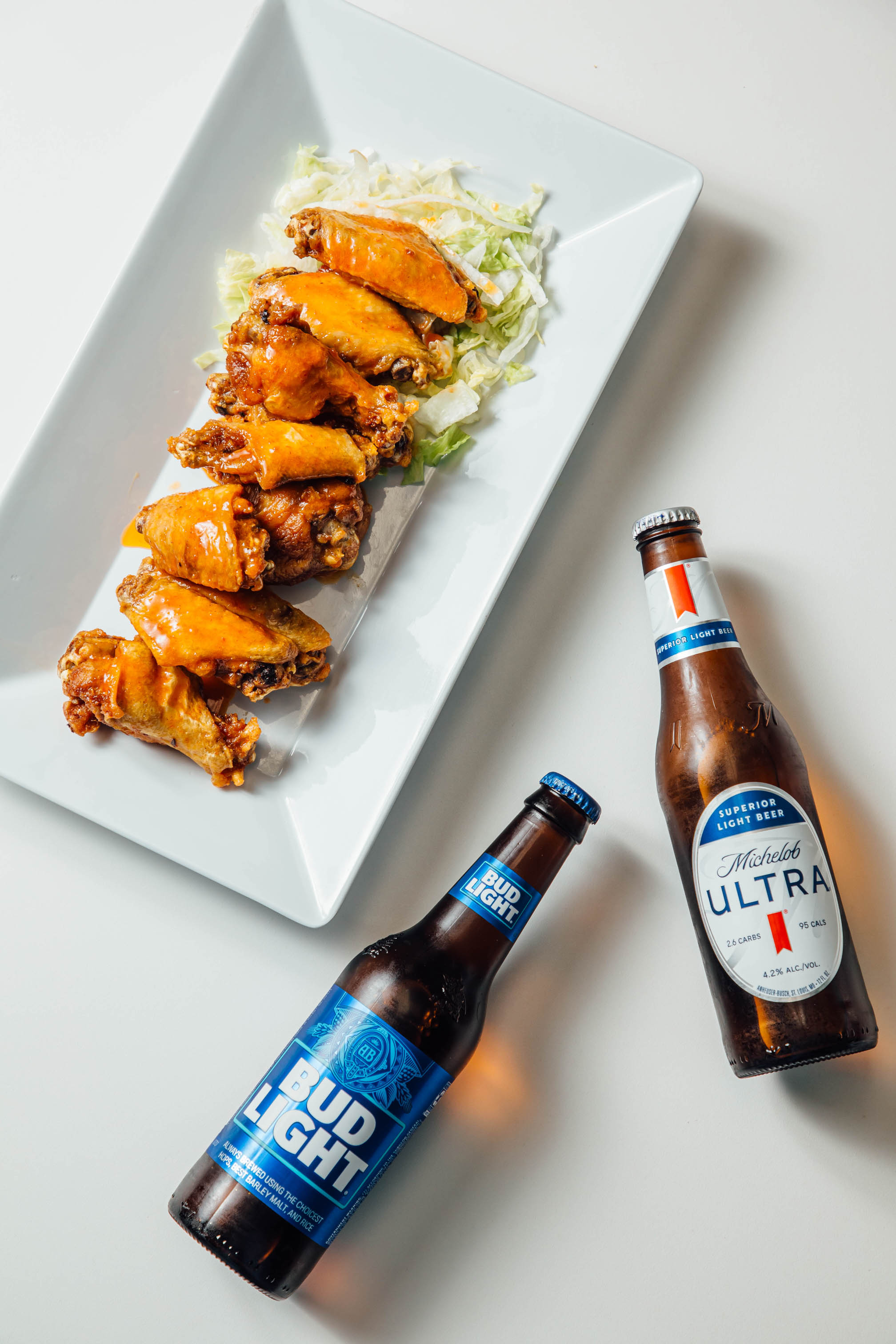 Plate of chicken wings with two botteled beers