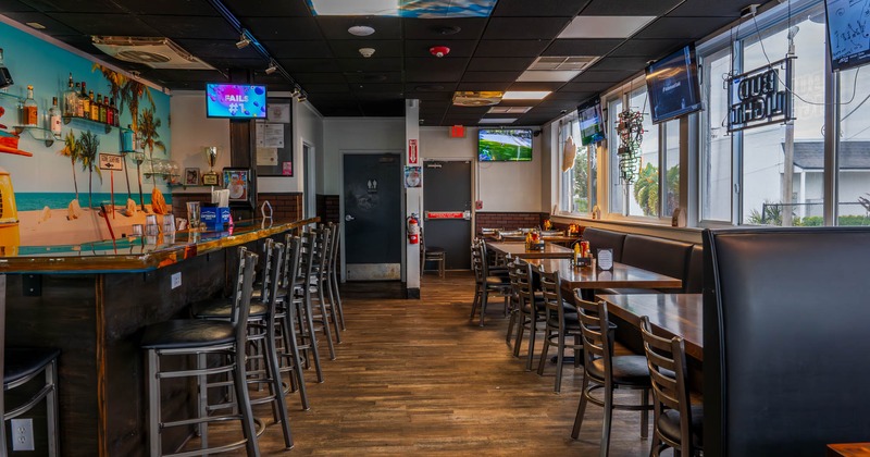 Interior, bar and bar stools on the left, tables and chairs on the right