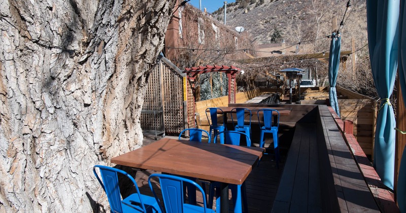 Exterior, patio, large tree, wooden corner banquette seating, tables and chairs