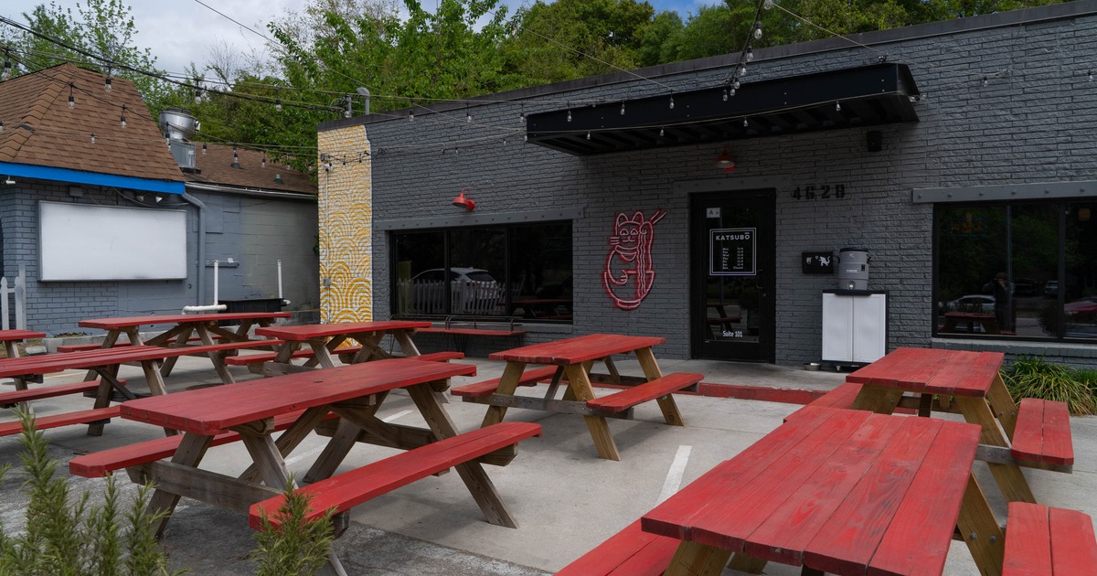 Outdoor dining area with red picnic tables in front of the restaurant