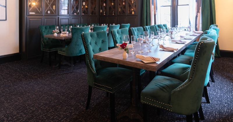 Private space inside the restaurant with long set tables and upholstered chairs