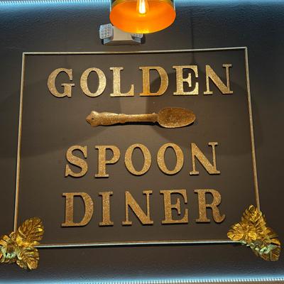 Close-up of the Golden Spoon Diner sign under warm lighting.