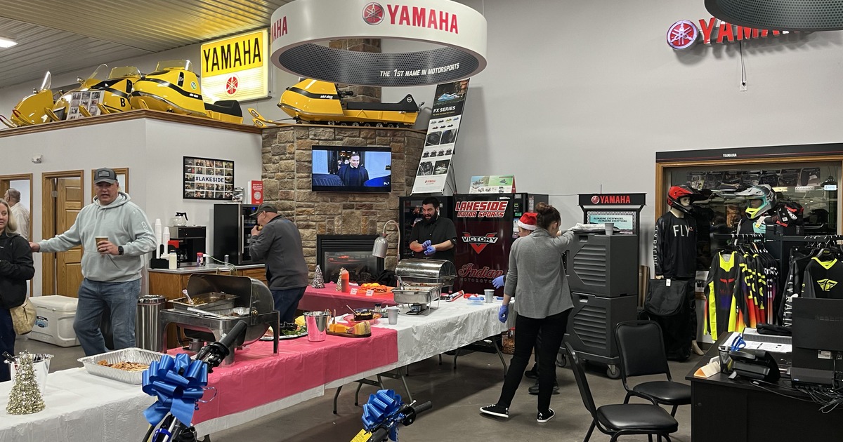 Motor company dealership indoor event with catering table and parked motorcycles