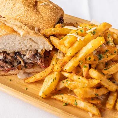 Sliced filet mignon sandwich served with Parmesan truffle fries.