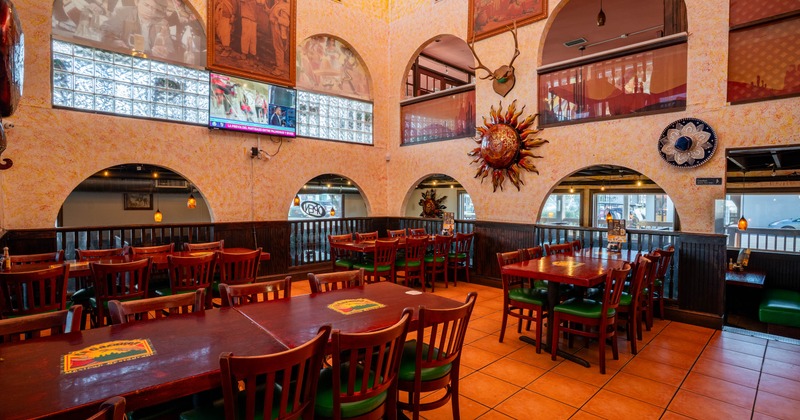 Cozy interior with arched windows, wooden furniture and various wall decorations