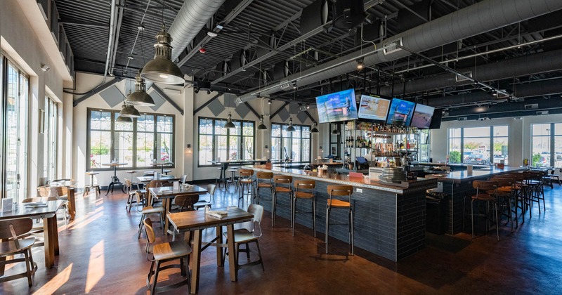 Interior, tables and chairs, bar in the middle, ventilation pipes on the ceiling