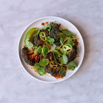 Roasted broccoli garnished with fresh cilantro and sliced jalapeños.