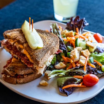 Corned Beef Rueben sandwich, served with a salad.