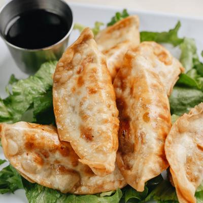 Fried potstickers on leafy greens.