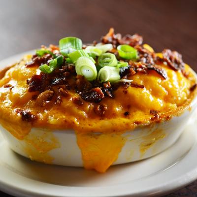 Baked mac and cheese topped with bacon and scallions.