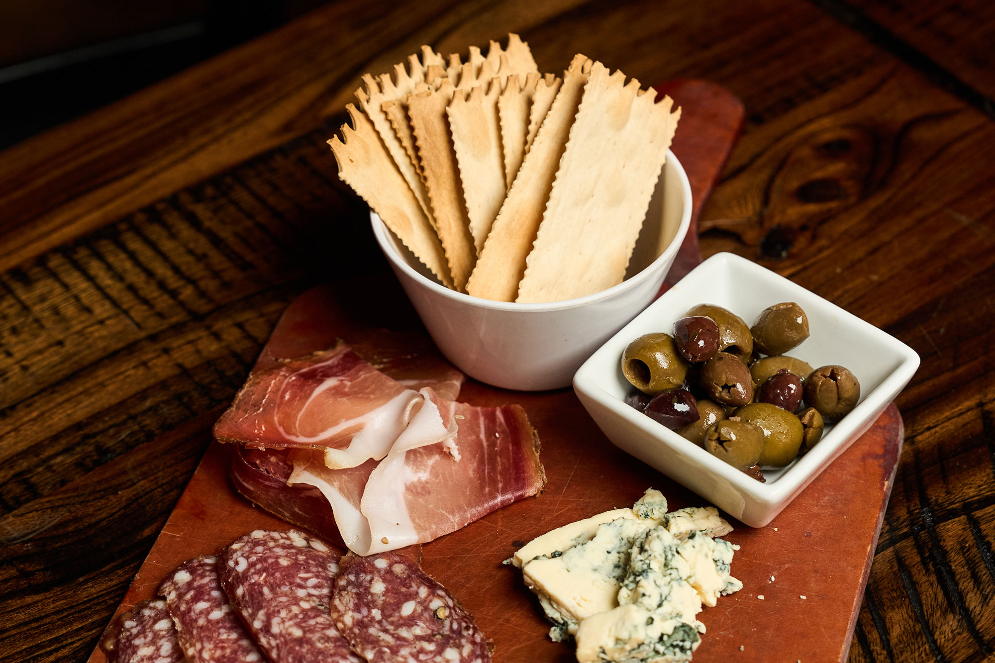Charcuterie board, crackers, cured meats, olives and cheese