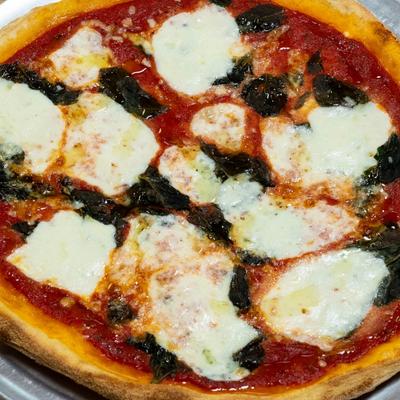 Margherita pizza topped with fresh mozzarella, tomato sauce, and basil.