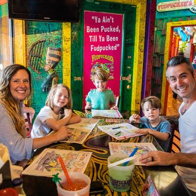 Interior, A family sitting at a dining table and smiling at the camera.