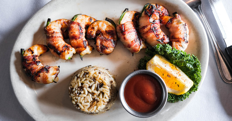 Grilled shrimp wrapped in bacon, served with rice and sauce dip