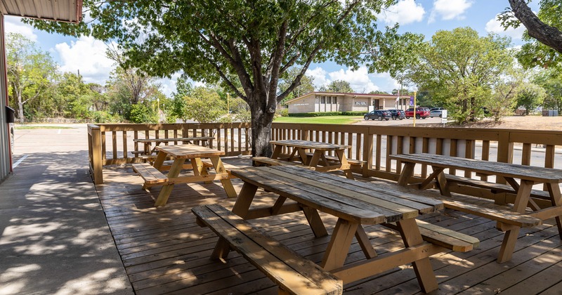 Outdoor seating area with conjoining wooden tables and benches