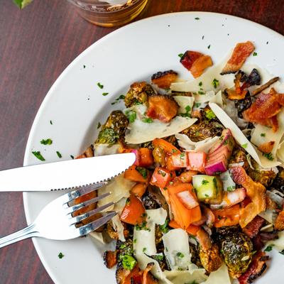 Brussel sprouts topped with diced vegetables.