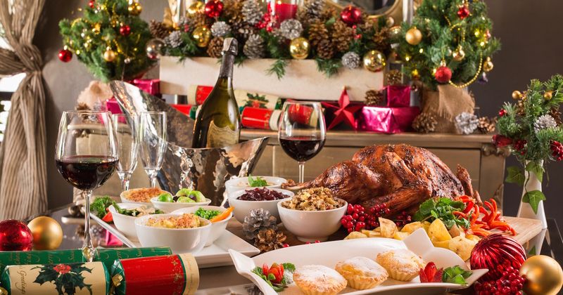 Christmas table with various dishes, wine and decorations