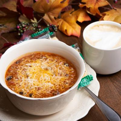 Bowl of chili, topped with shredded cheese.