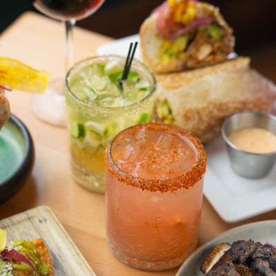 Assorted cocktails with food plates.