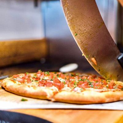 A large blade cutting a pizza.