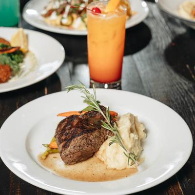 Grilled steak, mashed potatoes, and a Tequila Sunrise cocktail.