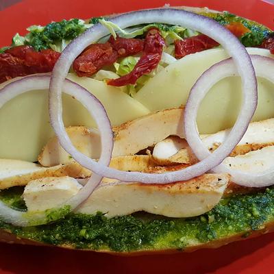 Chicken Pesto Sandwich, with red onion, lettuce, and sun dried tomatoes.