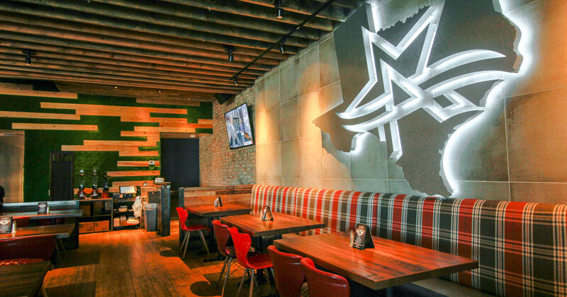 Big neon sign on wall above booth area