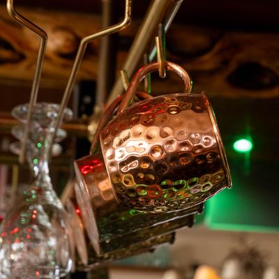 Mule copper mugs and glasses hanging from the rack.
