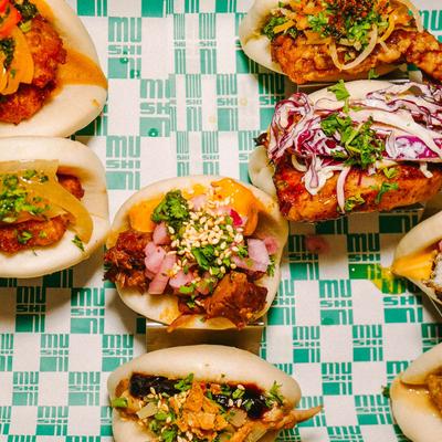Colorful stuffed buns spread across a patterned table.