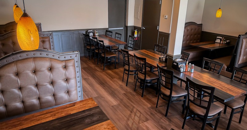 Interior of dining area with dining tables, chairs, and upholstered booths