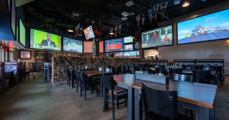 Interior, tables and chairs with hanging tv screens