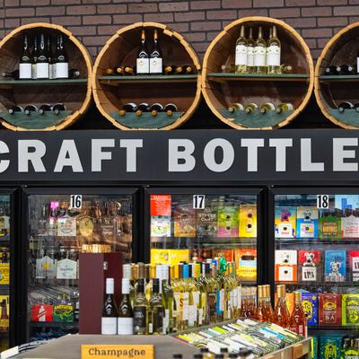 Wine bottles and beer bottles in the fridges.