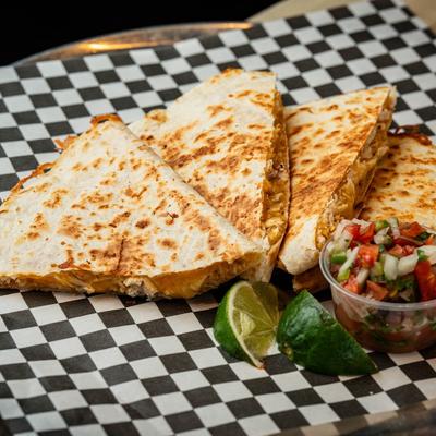 Quesadilla served with salsa and lime.