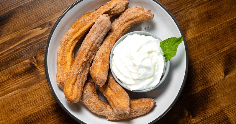 Churros served with caramel dipping sauce on the side