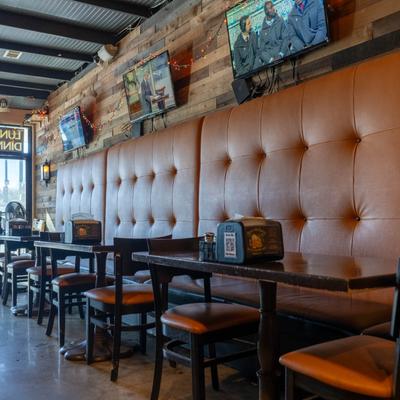 Interior with tables, leather seating, and TVs.