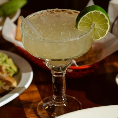 Margarita cocktail served in arimmed glass, with lime wheel as a garnish.